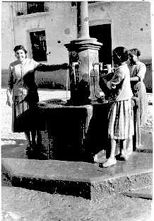 Recogiendo agua en el pilar de la plaza